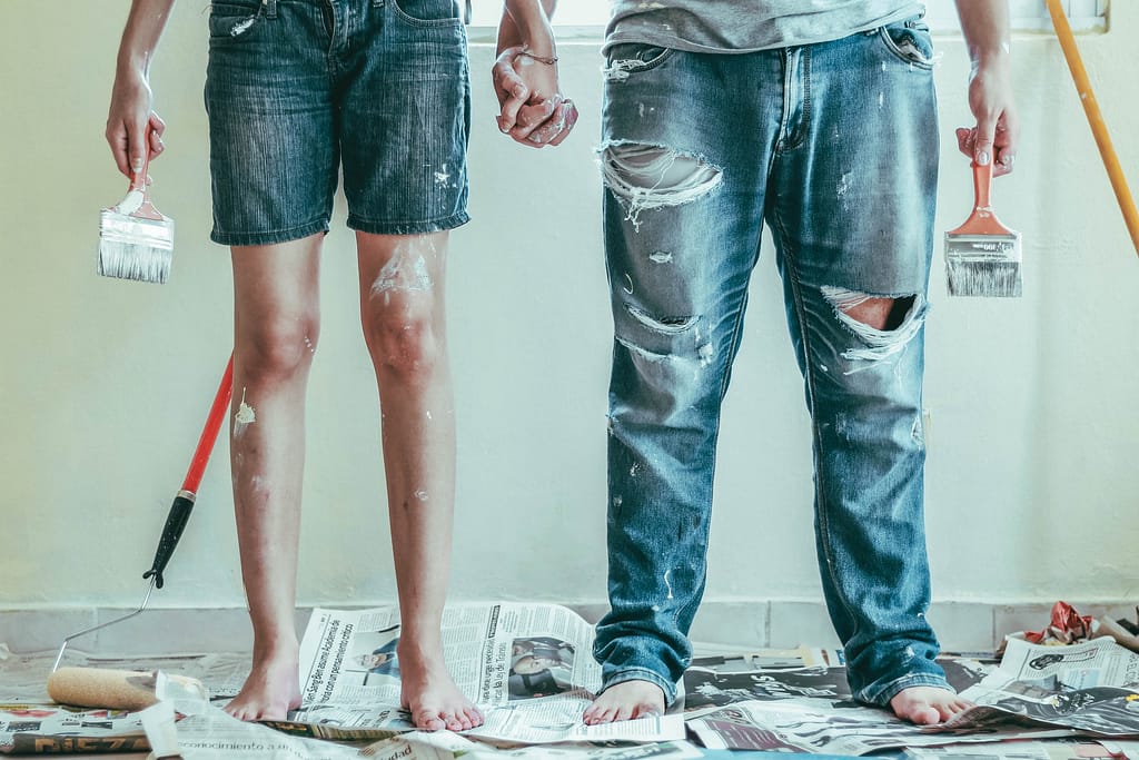 un uomo e una donna che armeggiano per ristrutturare una stanza della casa