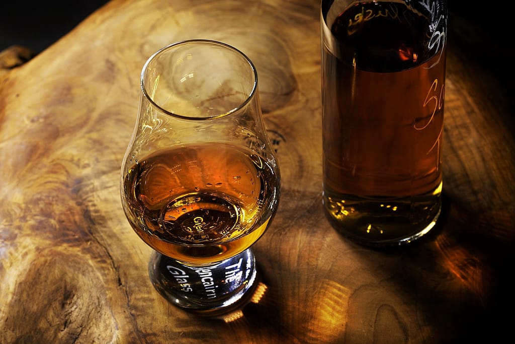 bicchiere di rum con accanto una bottiglia di rum