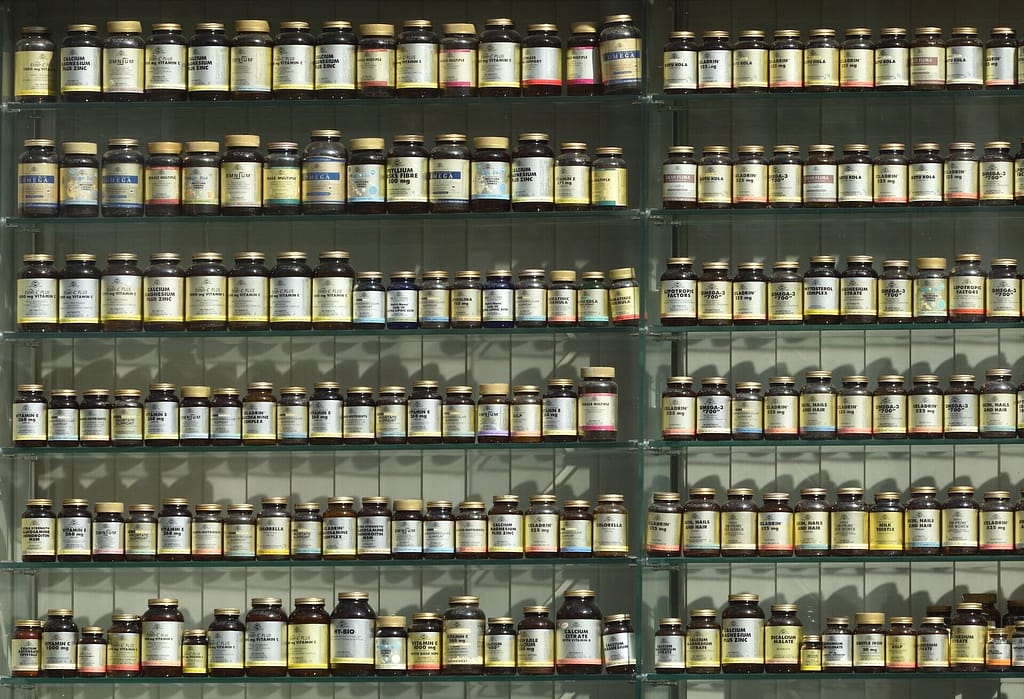 diversi scaffali pieni di integratori alimentari in una farmacia