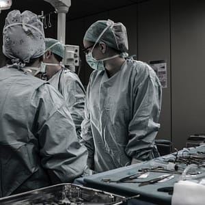 chirurghi che lavorano intorno a un tavolo operatorio in una clinica privata italiana